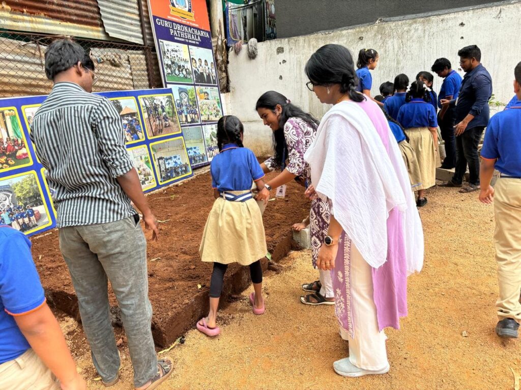 A teacher providing personalized attention to a student during an outdoor classroom activity at our Nallagandla school.