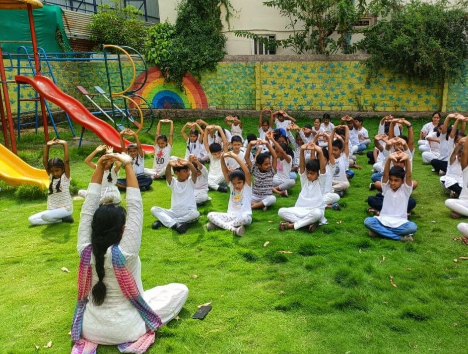 Students participating in an outdoor yoga session at GDP school near Tellapur, promoting mental and physical well-being.